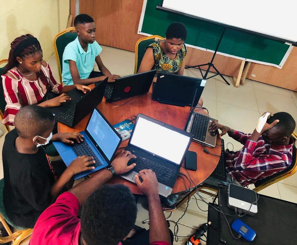 Teenagers collaborating and learning coding together in a classroom setting